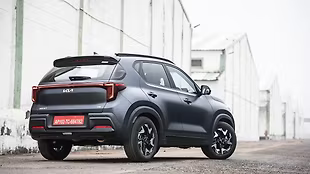 Rear spoiler, skid plates with metallic accents, and vertical tail lamps linked by a strip across the boot lid make for a striking rear view